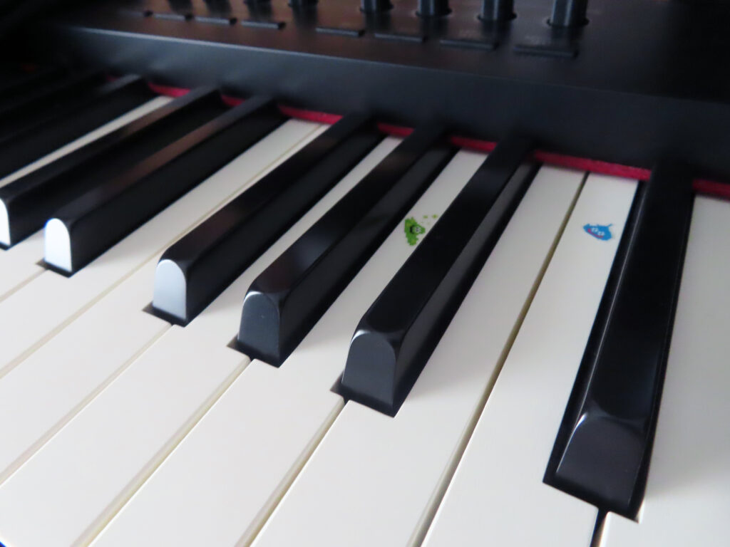 piano keys with dragon quest slime stickers on its